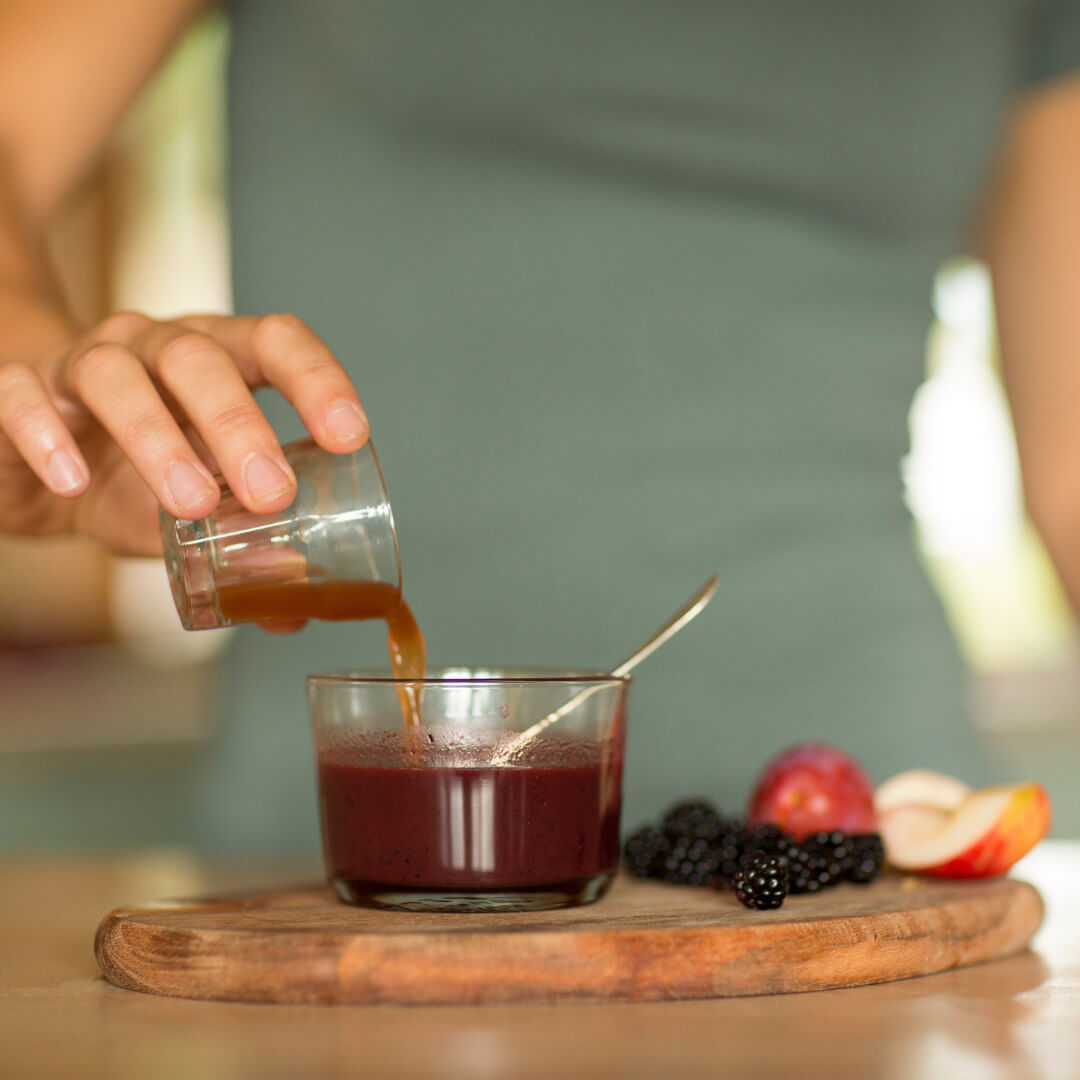 Frau mit Schnapsglas Vita Biosa Beeren Kräuter Apfel Frucht Brombeeren